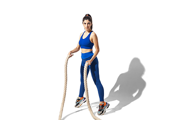 Image showing Beautiful young female athlete practicing on white studio background with shadows