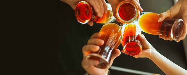 Image showing Hands of young friends, colleagues during beer drinking, having fun, laughting and celebrating together. Flyer with copyspace