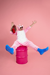 Image showing Senior hipster man in stylish pink attire isolated on pink background. Tech and joyful elderly lifestyle concept