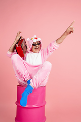 Image showing Senior hipster man in stylish pink attire isolated on pink background. Tech and joyful elderly lifestyle concept