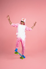 Image showing Senior hipster man in stylish pink attire isolated on pink background. Tech and joyful elderly lifestyle concept