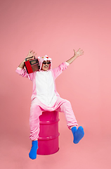 Image showing Senior hipster man in stylish pink attire isolated on pink background. Tech and joyful elderly lifestyle concept