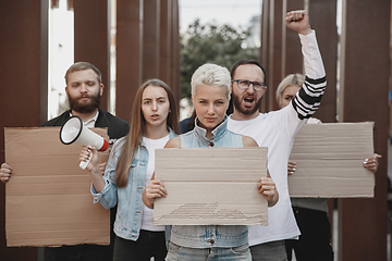 Image showing Group of activists giving slogans in a rally. Men and women marching together in a protest in the city.