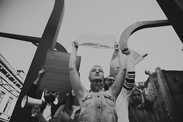 Image showing Group of activists giving slogans in a rally. Men and women marching together in a protest in the city.