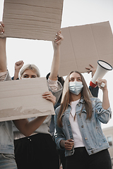 Image showing Group of activists giving slogans in a rally. Men and women marching together in a protest in the city.