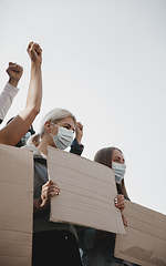 Image showing Group of activists giving slogans in a rally. Men and women marching together in a protest in the city.