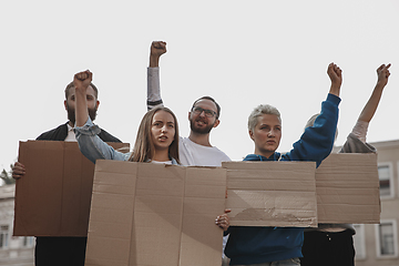 Image showing Group of activists giving slogans in a rally. Men and women marching together in a protest in the city.