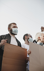 Image showing Group of activists giving slogans in a rally. Men and women marching together in a protest in the city.