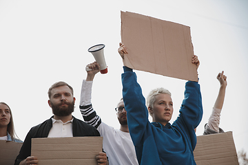 Image showing Group of activists giving slogans in a rally. Men and women marching together in a protest in the city.