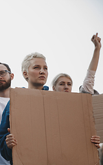 Image showing Group of activists giving slogans in a rally. Men and women marching together in a protest in the city.