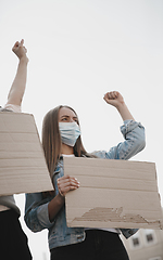 Image showing Group of activists giving slogans in a rally. Men and women marching together in a protest in the city.