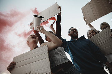 Image showing Group of activists giving slogans in a rally. Men and women marching together in a protest in the city.