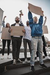 Image showing Group of activists giving slogans in a rally. Men and women marching together in a protest in the city.