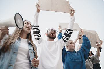 Image showing Group of activists giving slogans in a rally. Men and women marching together in a protest in the city.