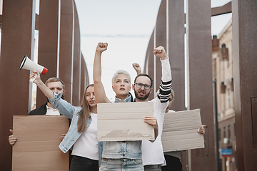 Image showing Group of activists giving slogans in a rally. Men and women marching together in a protest in the city.