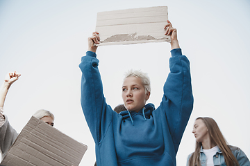 Image showing Group of activists giving slogans in a rally. Men and women marching together in a protest in the city.