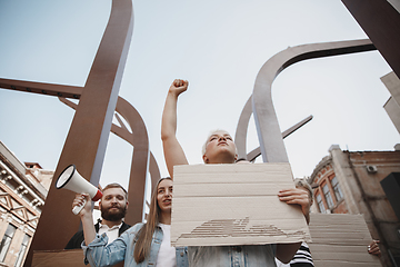 Image showing Group of activists giving slogans in a rally. Men and women marching together in a protest in the city.