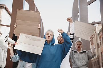 Image showing Group of activists giving slogans in a rally. Men and women marching together in a protest in the city.