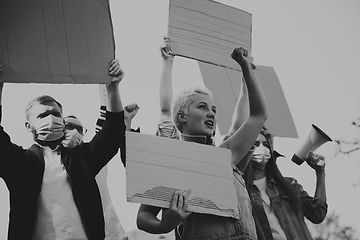 Image showing Group of activists giving slogans in a rally. Men and women marching together in a protest in the city.