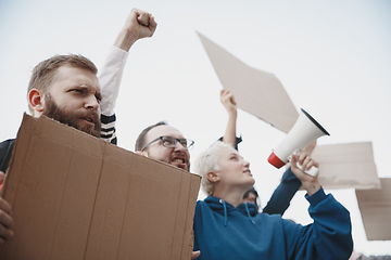 Image showing Group of activists giving slogans in a rally. Men and women marching together in a protest in the city.