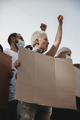 Image showing Group of activists giving slogans in a rally. Men and women marching together in a protest in the city.