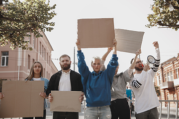 Image showing Group of activists giving slogans in a rally. Men and women marching together in a protest in the city.