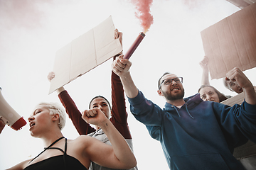 Image showing Group of activists giving slogans in a rally. Men and women marching together in a protest in the city.