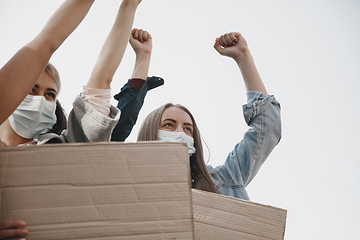 Image showing Group of activists giving slogans in a rally. Men and women marching together in a protest in the city.