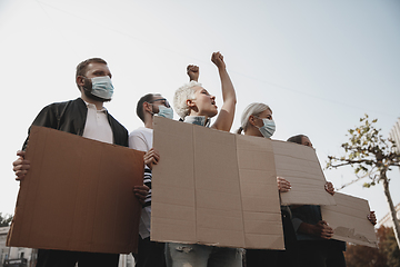 Image showing Group of activists giving slogans in a rally. Men and women marching together in a protest in the city.