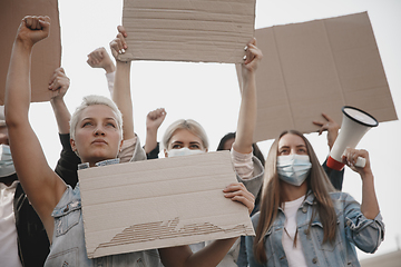 Image showing Group of activists giving slogans in a rally. Men and women marching together in a protest in the city.