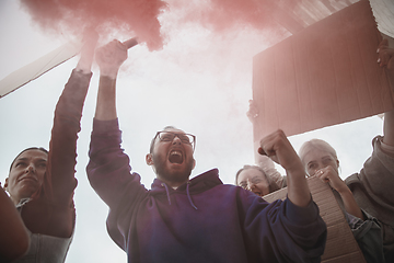 Image showing Group of activists giving slogans in a rally. Men and women marching together in a protest in the city.