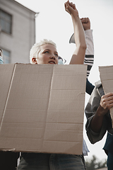 Image showing Group of activists giving slogans in a rally. Men and women marching together in a protest in the city.