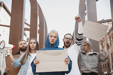 Image showing Group of activists giving slogans in a rally. Men and women marching together in a protest in the city.