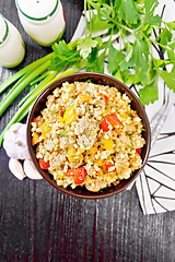 Image showing Barley porridge with minced meat in bowl on dark board top