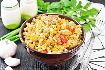 Image showing Barley porridge with minced meat in bowl on dark board