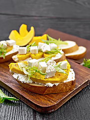 Image showing Bruschetta with pumpkin and arugula on black board