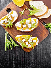 Image showing Bruschetta with pumpkin and arugula on dark board top