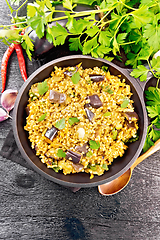 Image showing Bulgur with eggplant in pan on dark board top