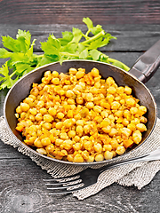 Image showing Chickpeas stewed with vegetables in pan on black board