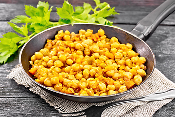 Image showing Chickpeas stewed with vegetables in pan on dark board