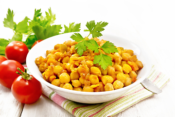 Image showing Chickpeas stewed with vegetables in plate on wooden board