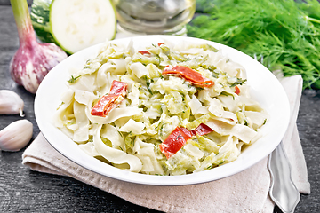 Image showing Fettuccine with zucchini and hot peppers in plate on board