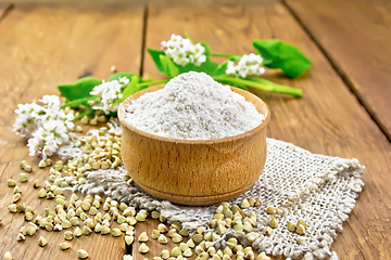 Image showing Flour buckwheat green in bowl with flowers on wooden board