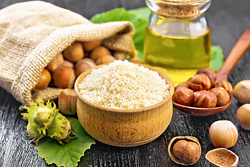 Image showing Flour in bowl with nuts on dark wooden board