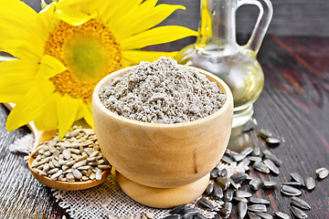 Image showing Flour sunflower in bowl with flower on wooden board