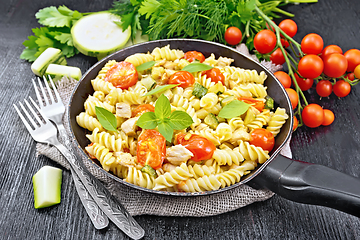 Image showing Fusilli with chicken and tomatoes in pan on black board
