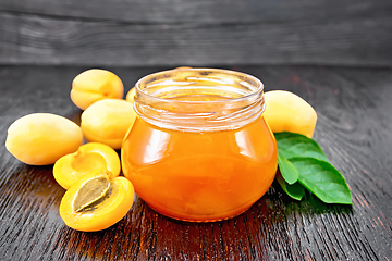 Image showing Jam apricot in jar on dark board