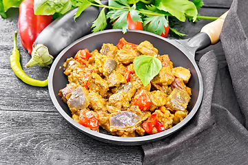 Image showing Meat with eggplant and pepper in pan on dark board