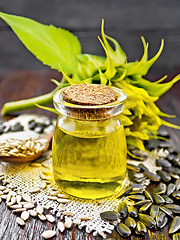 Image showing Oil sunflower in jar with flower on dark board