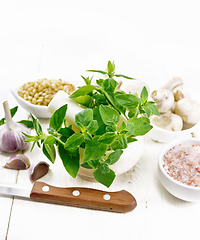 Image showing Oregano fresh in mortar on wooden board